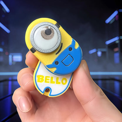 The Curious Mind Minion Pocket Push Pop Clicker fidget toy in yellow and blue with a single eye and 'BELLO' text.