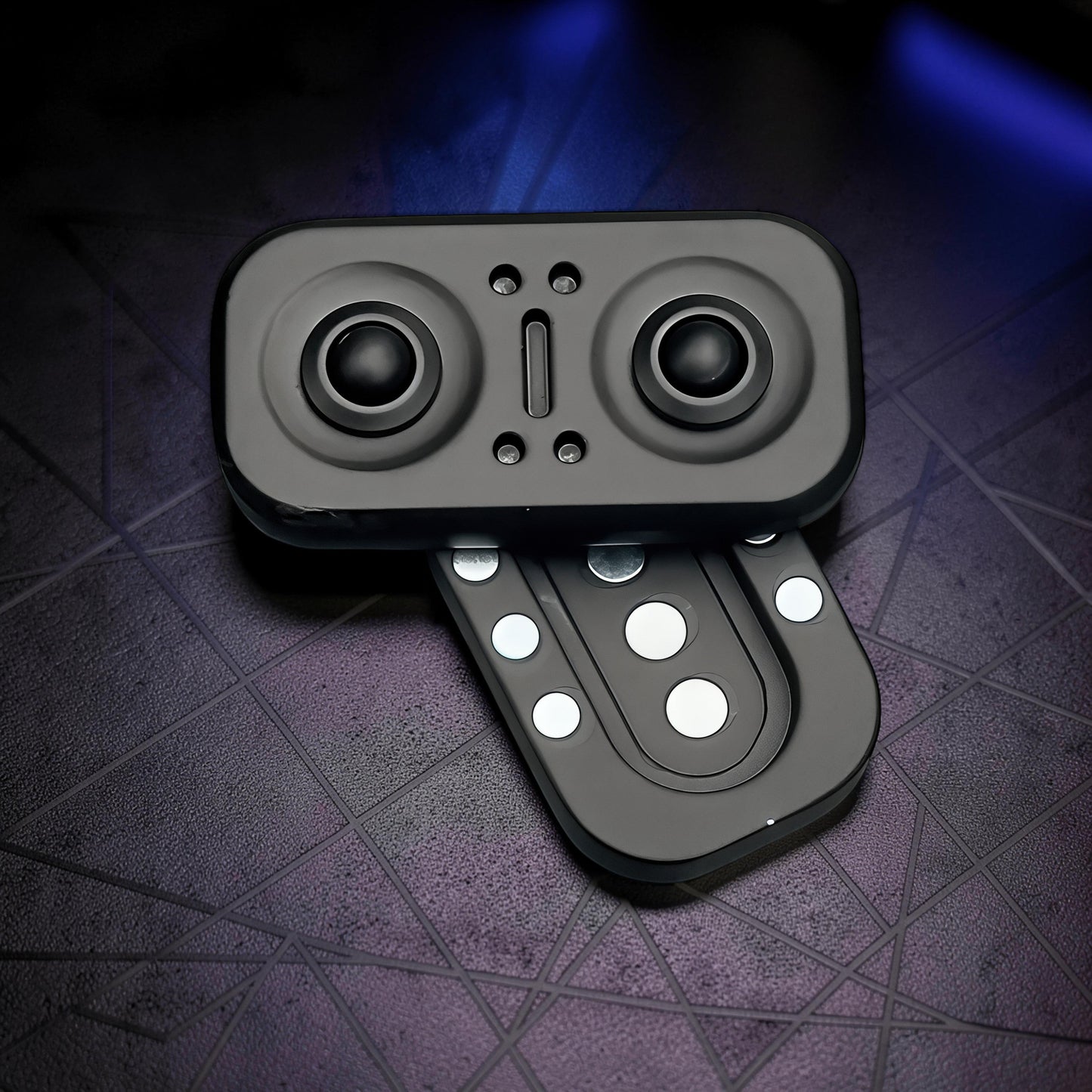 The Curious Mind Owl Push Slider, a compact black metal fidget toy with a push-and-return slider action and magnetic elements.