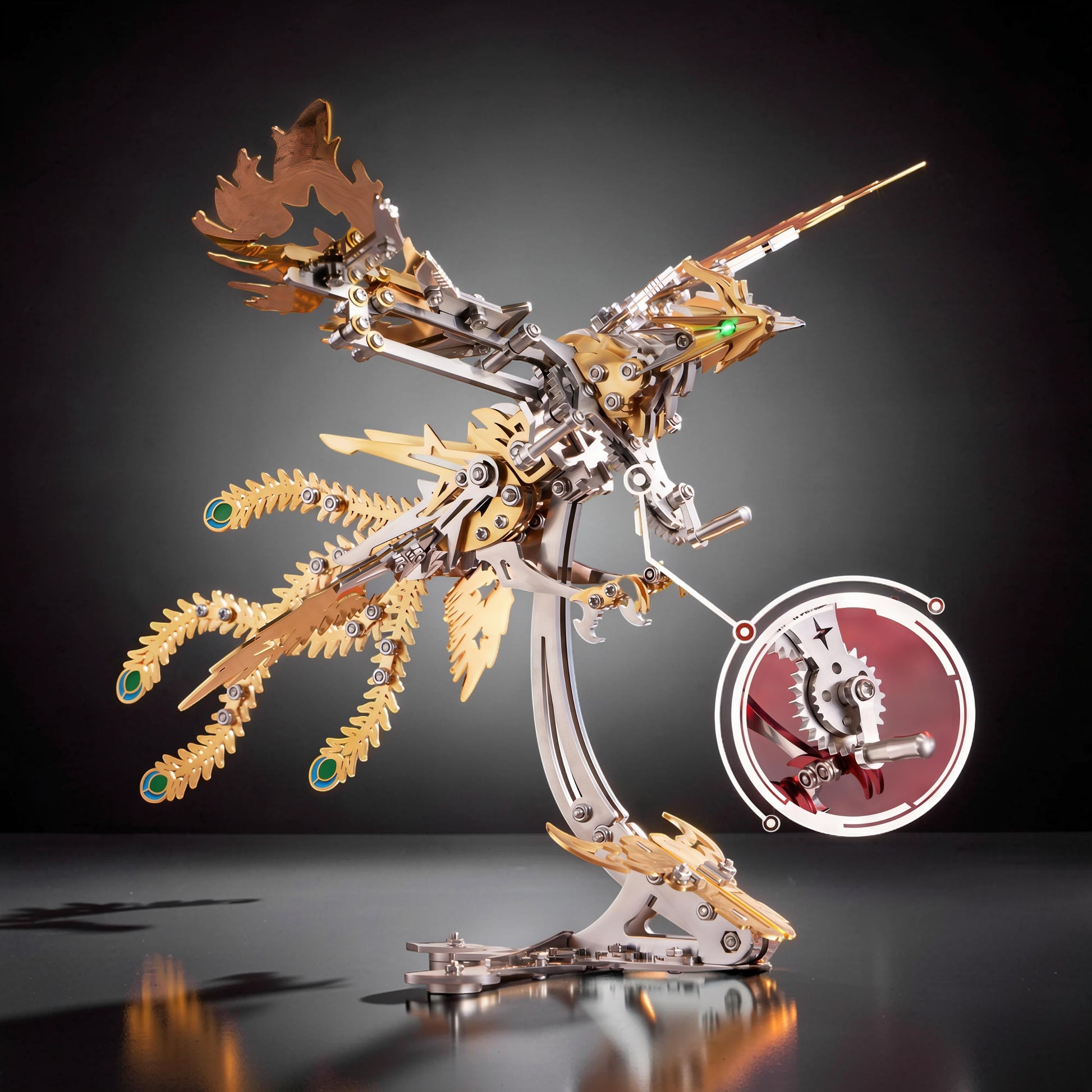 The Curious Mind Phoenix DIY Kit, a mechanical metal model in silver and gold with intricate details and green eye accents. Features a detailed stand and a close-up inset of gears.