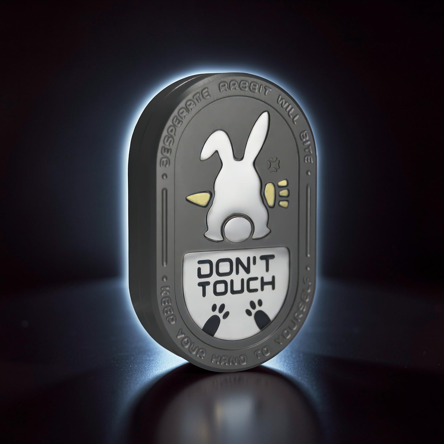 The Curious Mind Don't Touch Rabbit Slider fidget toy with a grey metal body, featuring a white rabbit design and 'Don't Touch' text.