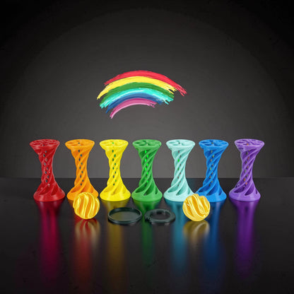 The Curious Mind Rainbow Spiral Ejection Ball fidget toy in red, orange, yellow, green, light blue, blue, and purple. Includes yellow balls and black rings.