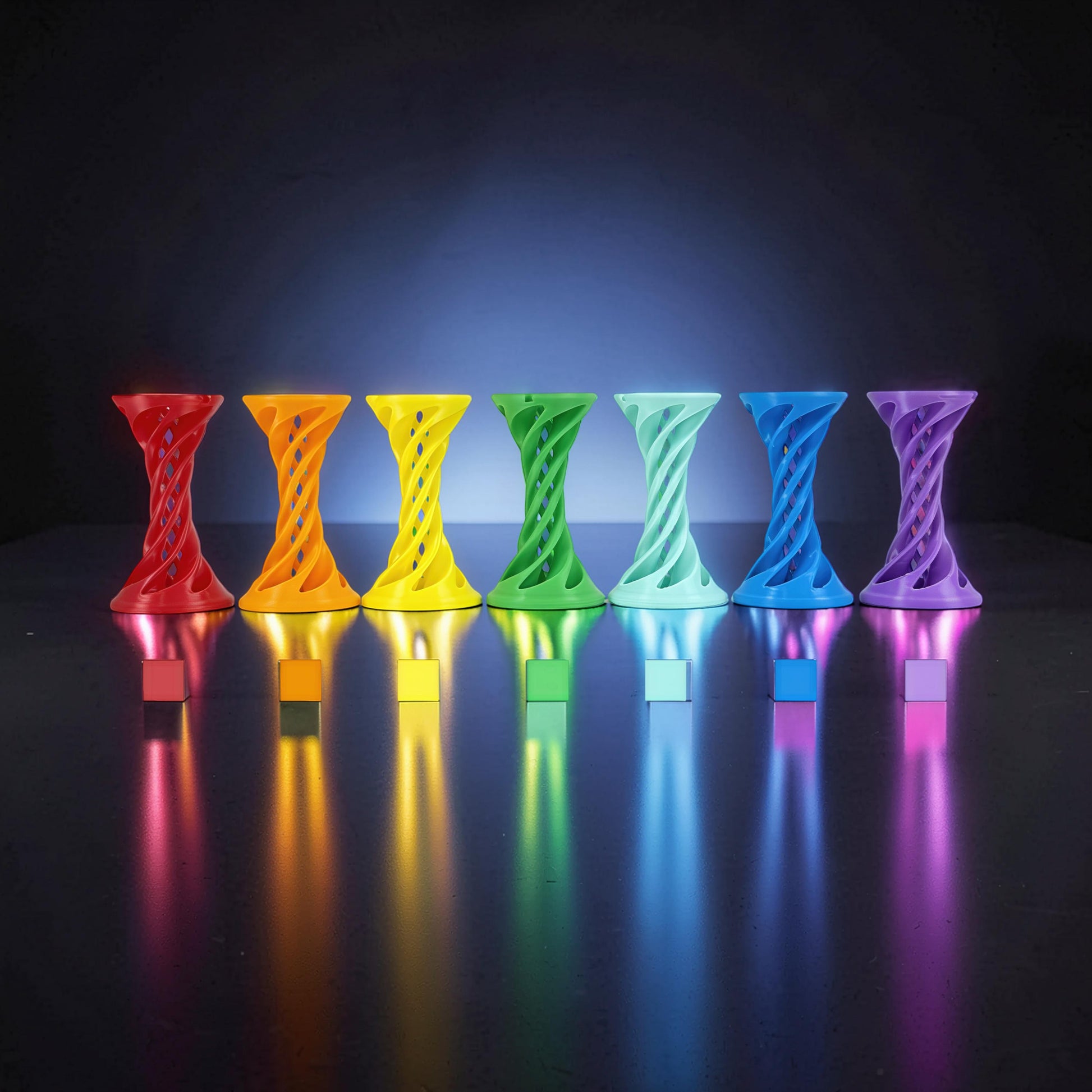 The Curious Mind Rainbow Spiral Ejection Ball fidget toy in red, orange, yellow, green, light green, blue, and purple, made of PLA.