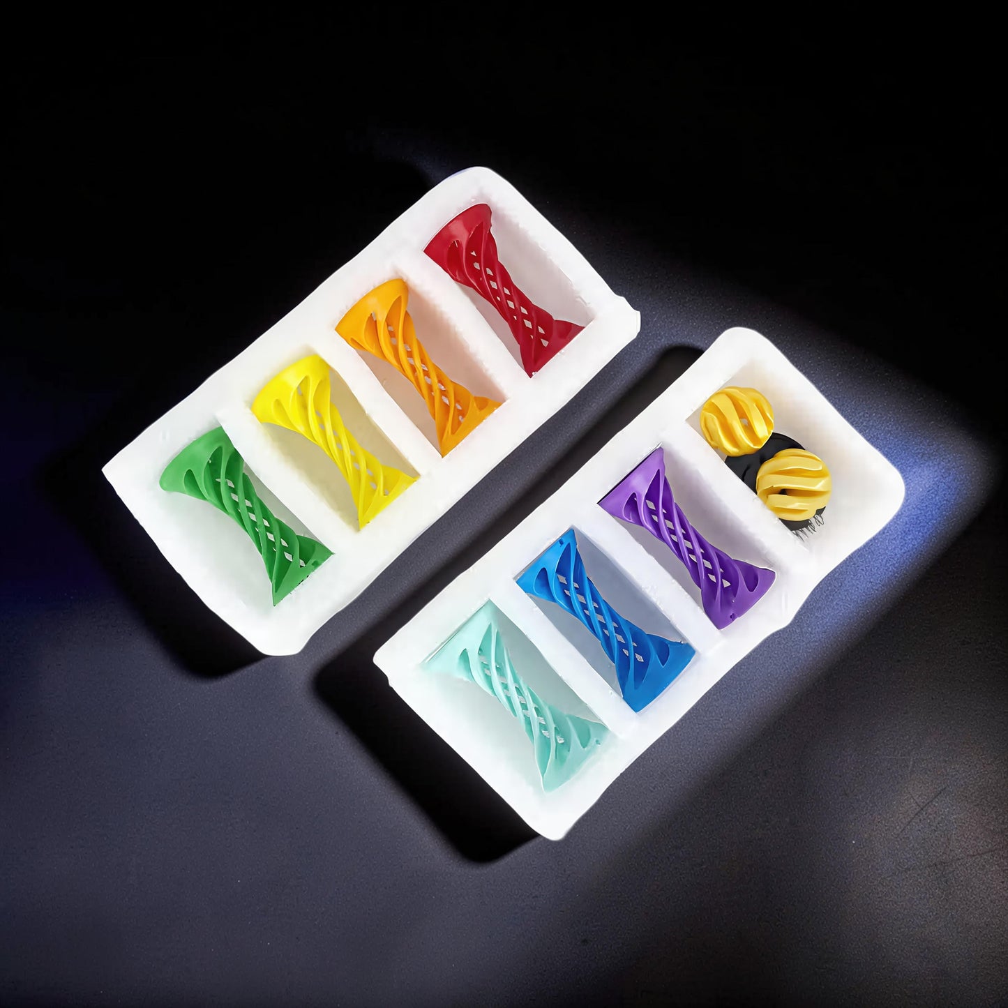 The Curious Mind Rainbow Spiral Ejection Balls in green, yellow, orange, red, mint, blue, and purple, made of PLA plastic.