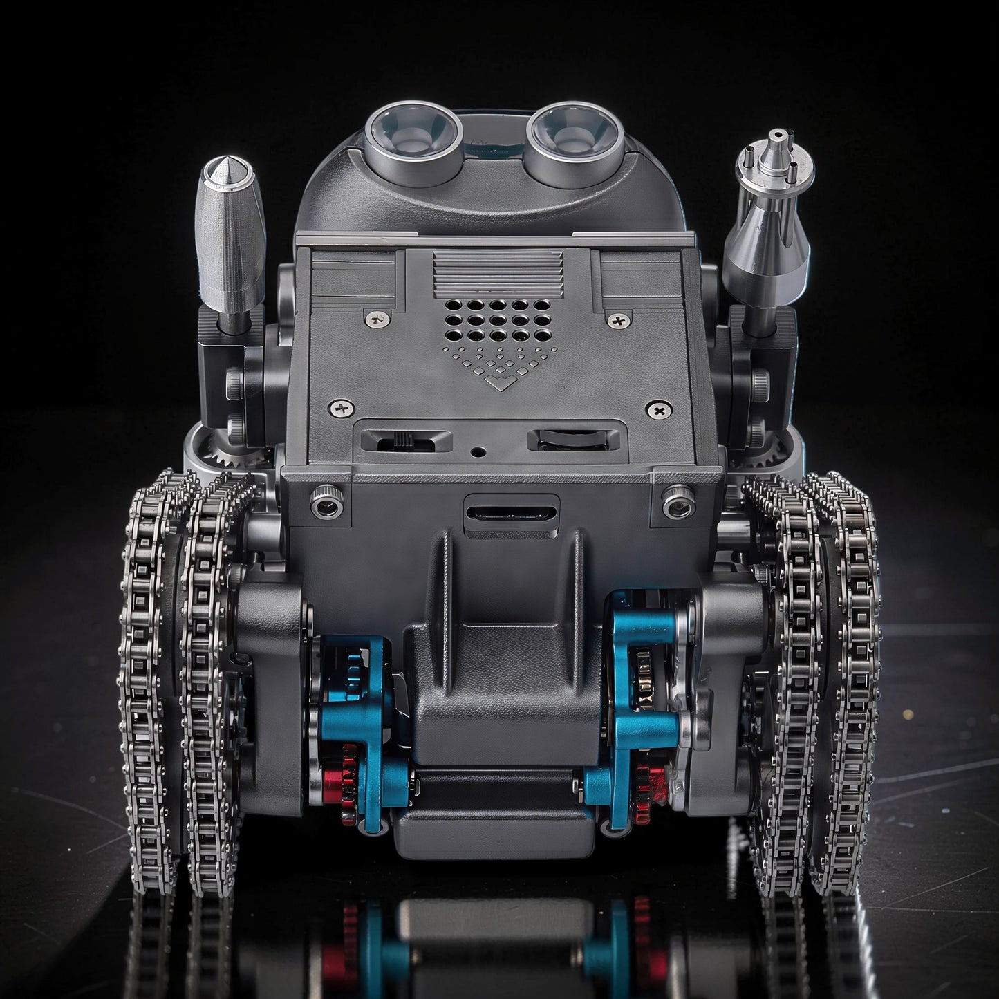 The Curious Mind RC Tank Robot DIY Kit features a metallic grey body with dual tracks, blue and red mechanical accents, and a distinctive head with two large lenses.