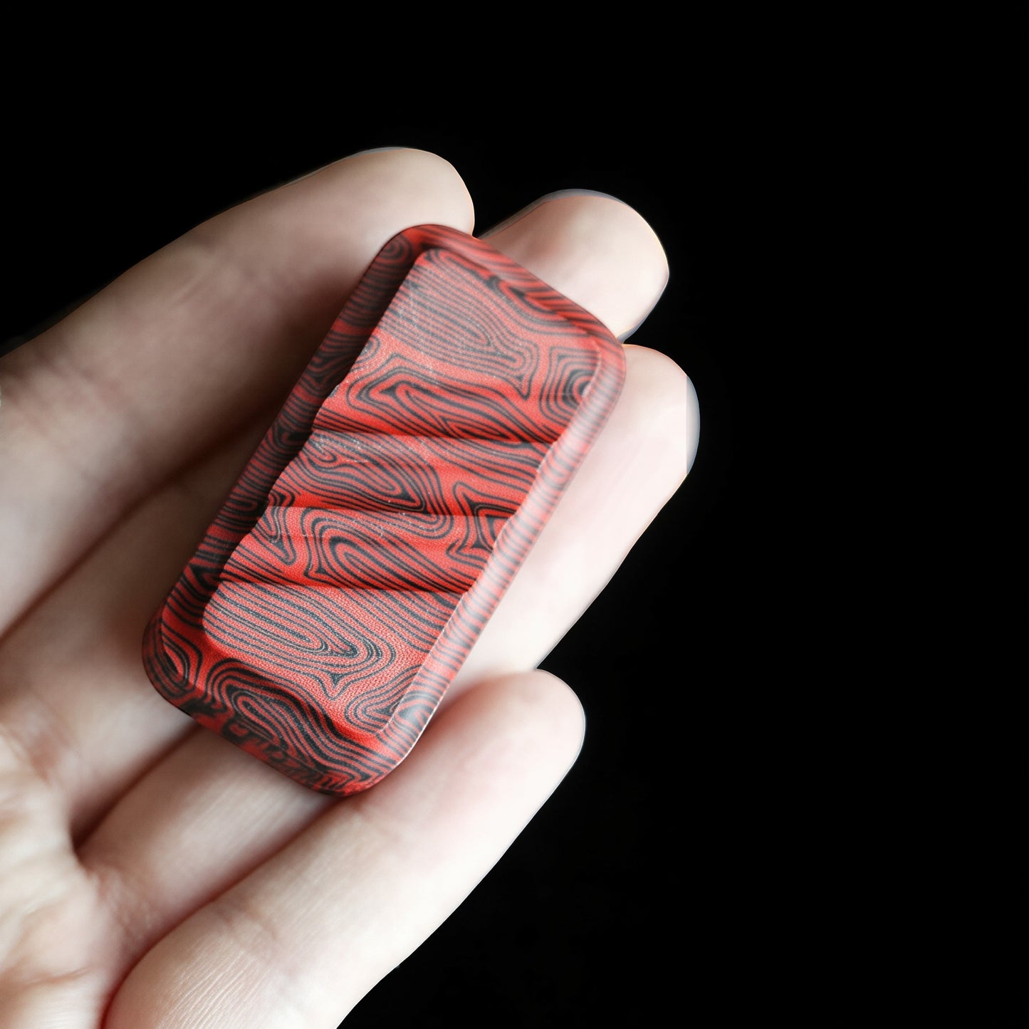 The Curious Mind Three-Layer Push Card Slider fidget toy with red and black wavy pattern. Compact fiberglass design.