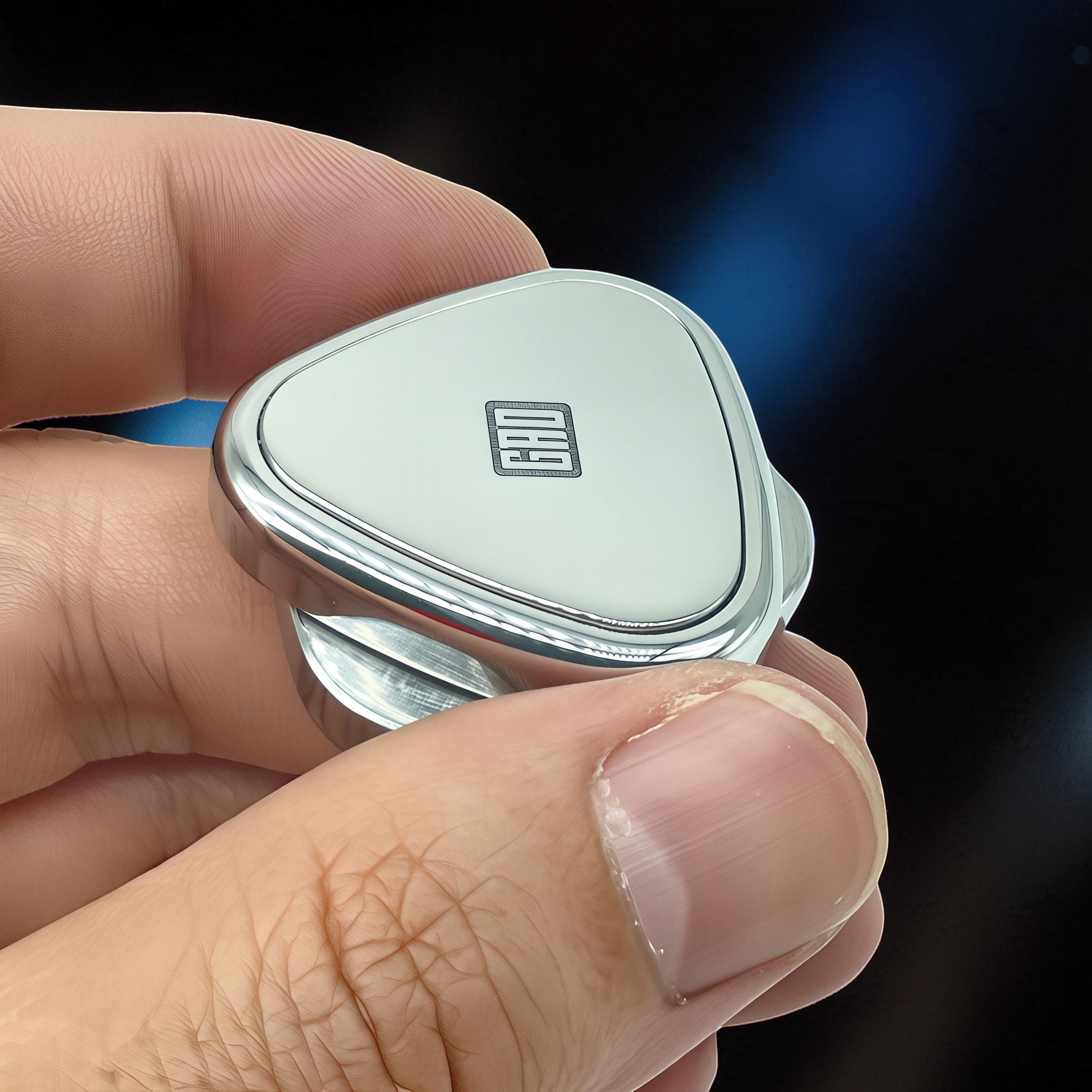 The Curious Mind Rice Ball Push Card Fidget, a compact metal slider with a white face and a black logo, held in a hand.