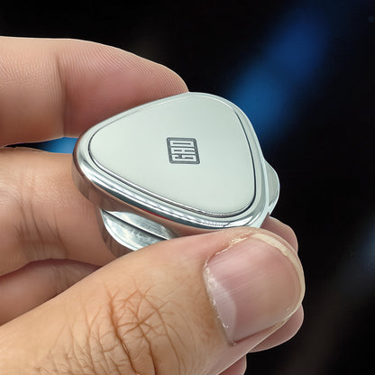 The Curious Mind Rice Ball Push Card Fidget, a compact metal slider with a white face and a black logo, held in a hand.