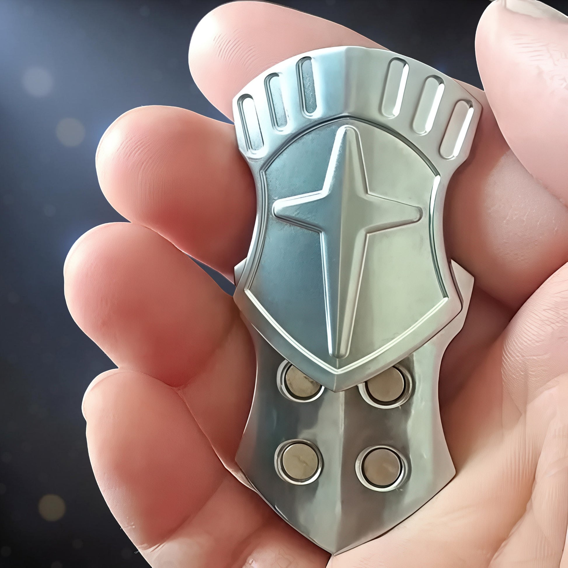 The Curious Mind Shield Fingertip Spinner, a compact metal fidget toy with a silver shield design and tactile buttons.
