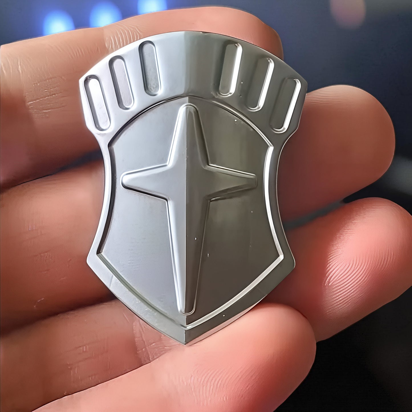 The Curious Mind Shield Fingertip Spinner, a compact EDC metal spinner with a shield design and star emblem, held in a hand.
