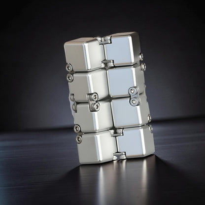 The Curious Mind Unlimited Magic Fidget Cube, a silver metal desk toy with a compact, modular design and satisfying tactile movement.