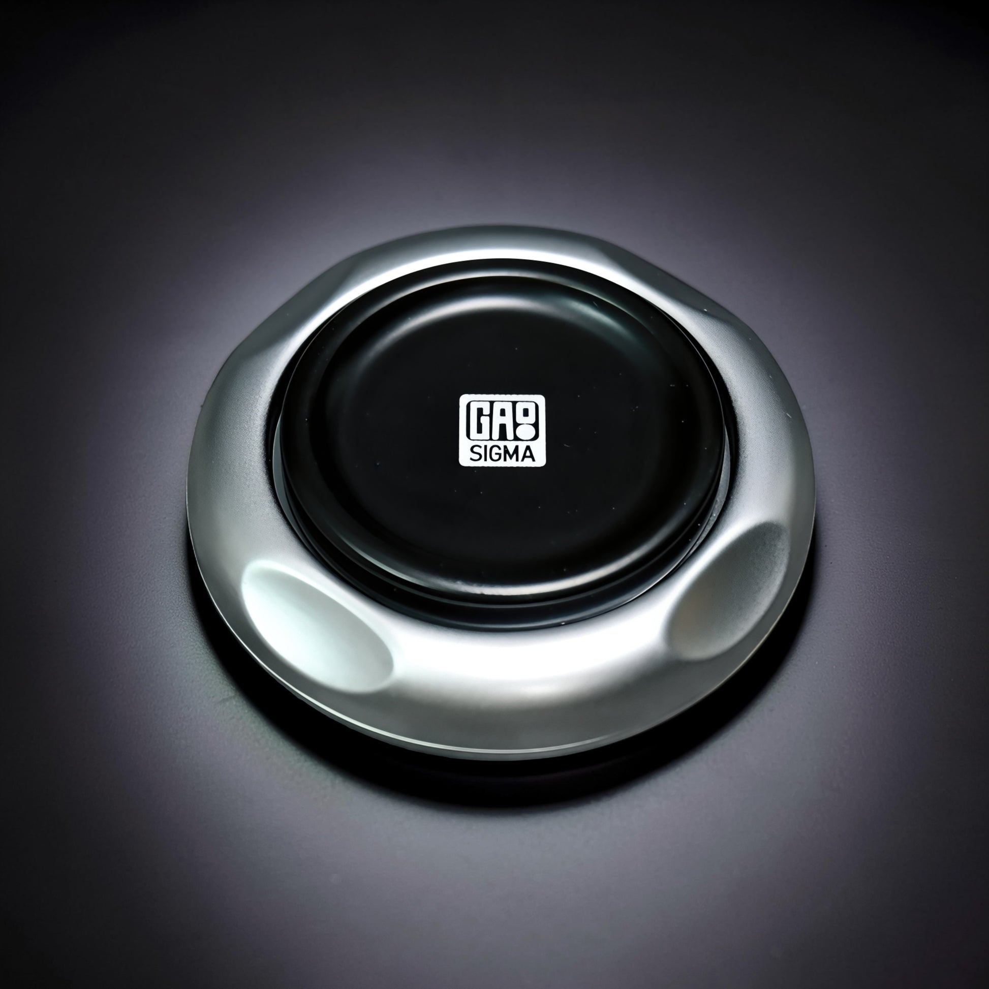 The Curious Mind Magnetic Master 2.0 spinner in silver metal with a black center featuring the GAS SIGMA logo.