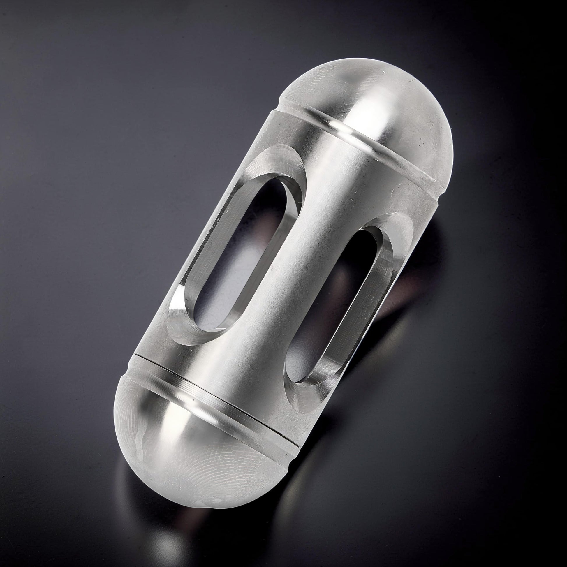 The Curious Mind silver metal egg-shaped pocket spinner with cut-out details for fidgeting and desk display.