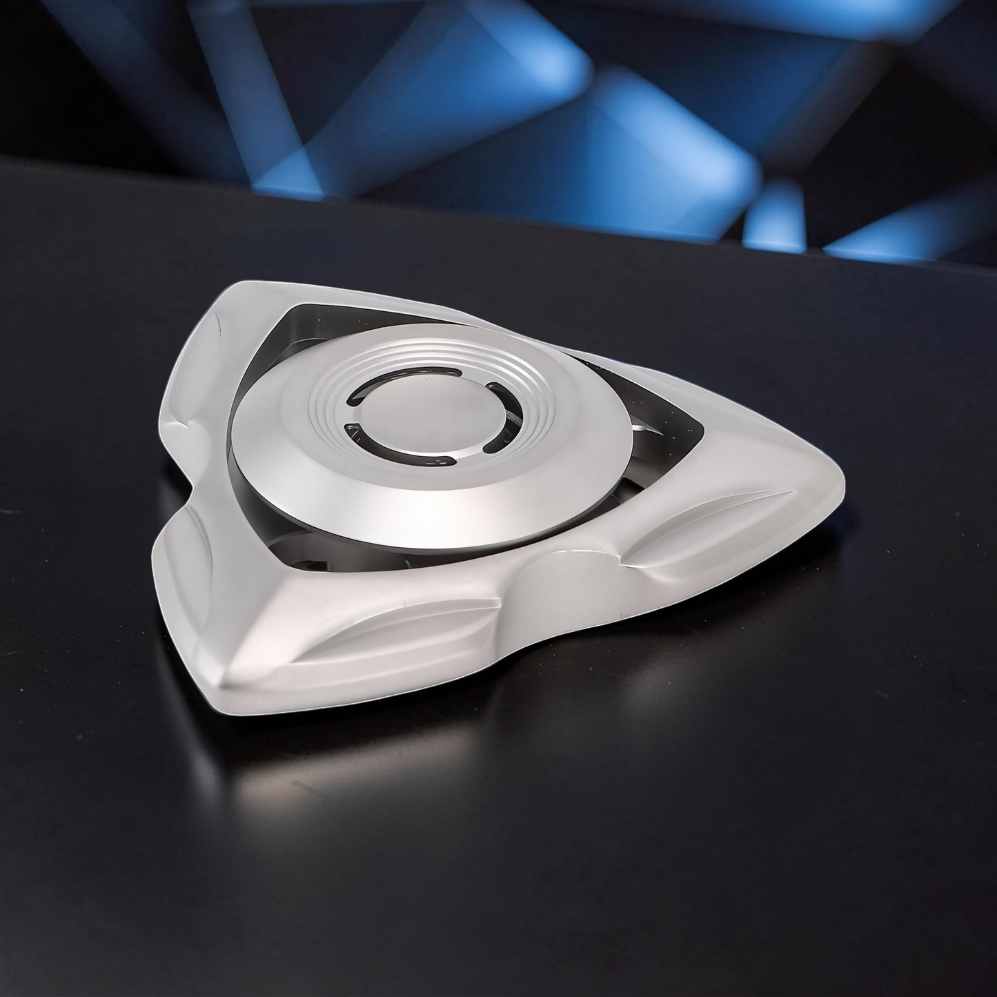 The Curious Mind silver stainless steel tri-blade spinner with a sleek, aerodynamic design. Perfect for EDC, desk toy, or gift.