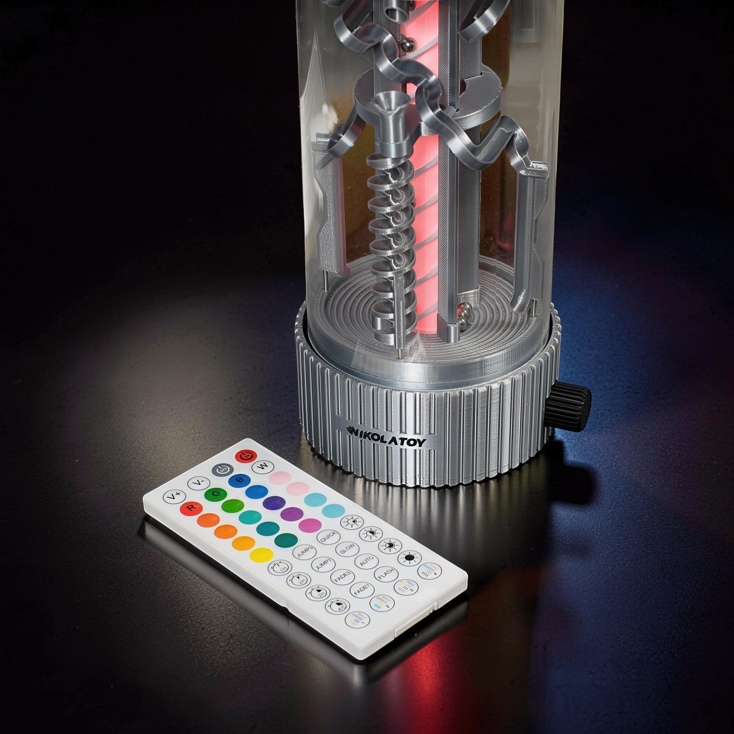The Curious Mind Spinning Pinball RGB Night Light with remote control. Silver PLA base and clear cylinder with internal spinning mechanism and red LED light.