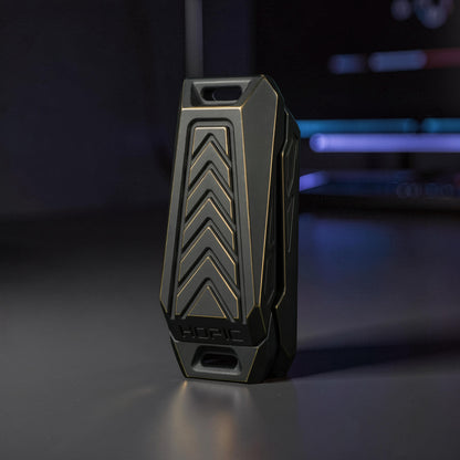 The Curious Mind Stainless Steel Chevron Slider fidget toy with a dark grey and gold chevron design. Compact metal push slider for stress relief.