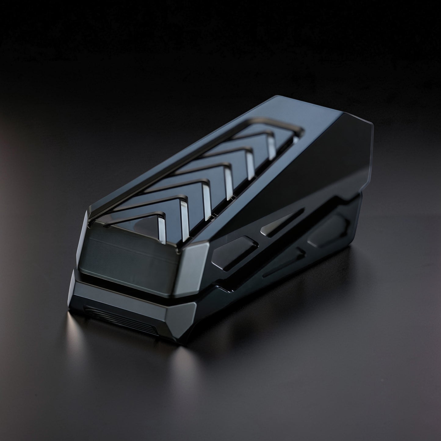 The Curious Mind Stainless Steel Chevron Slider fidget toy with a sleek, dark metallic finish and chevron pattern. Compact and tactile for stress relief.