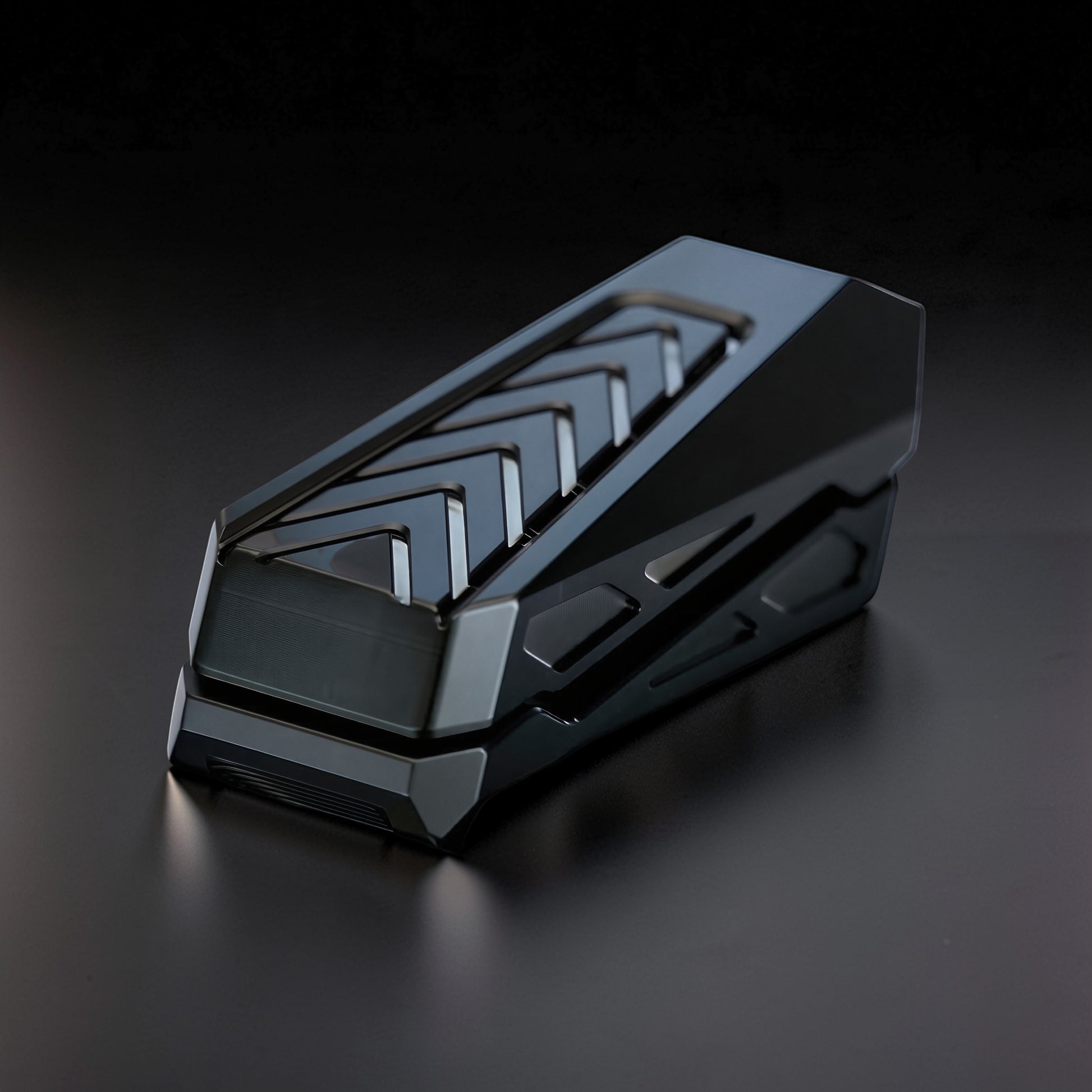The Curious Mind Stainless Steel Chevron Slider fidget toy with a sleek, dark metallic finish and chevron pattern. Compact and tactile for stress relief.