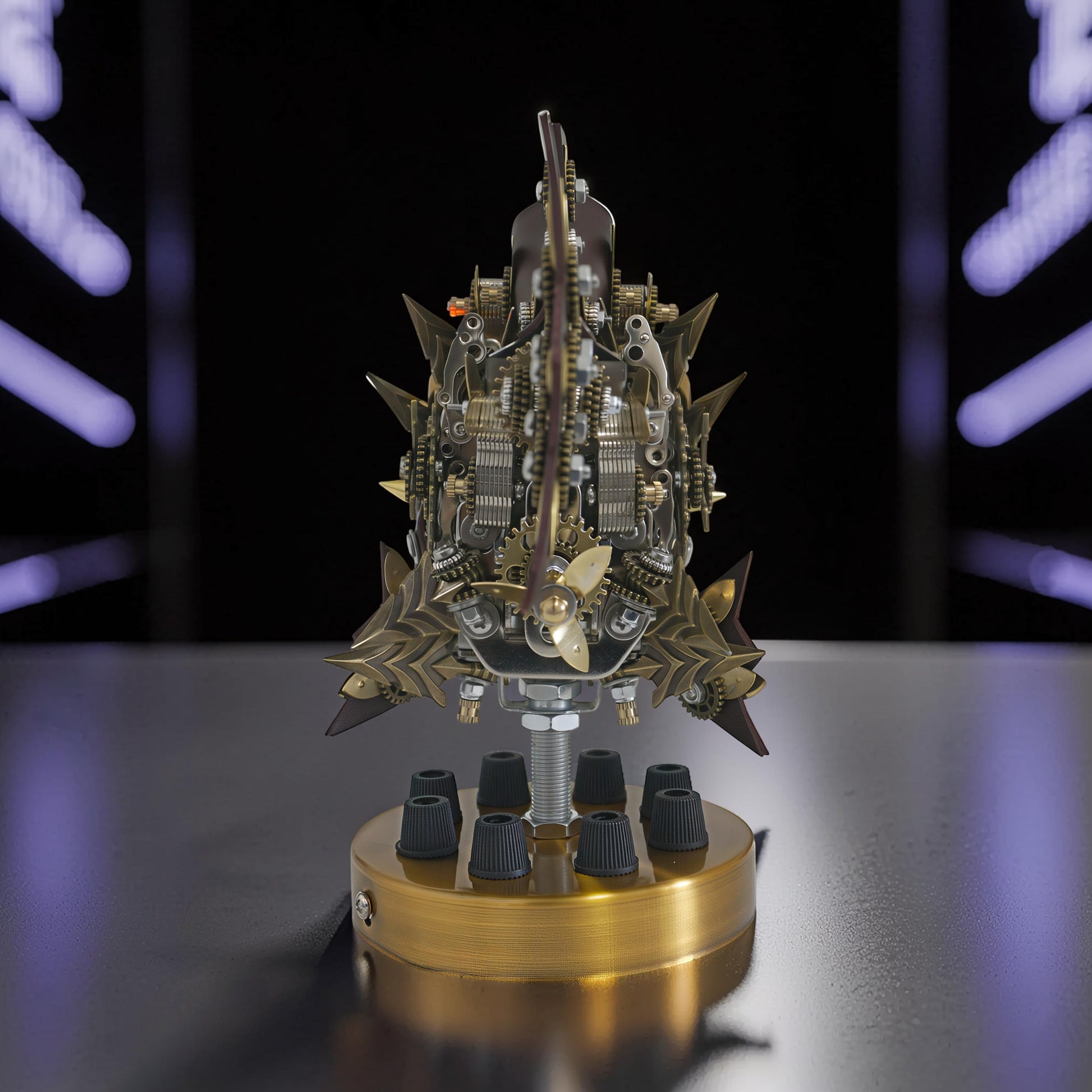 The Curious Mind Steampunk Anglerfish metal model kit with intricate gears and a brass propeller, displayed on a gold base with black knobs.