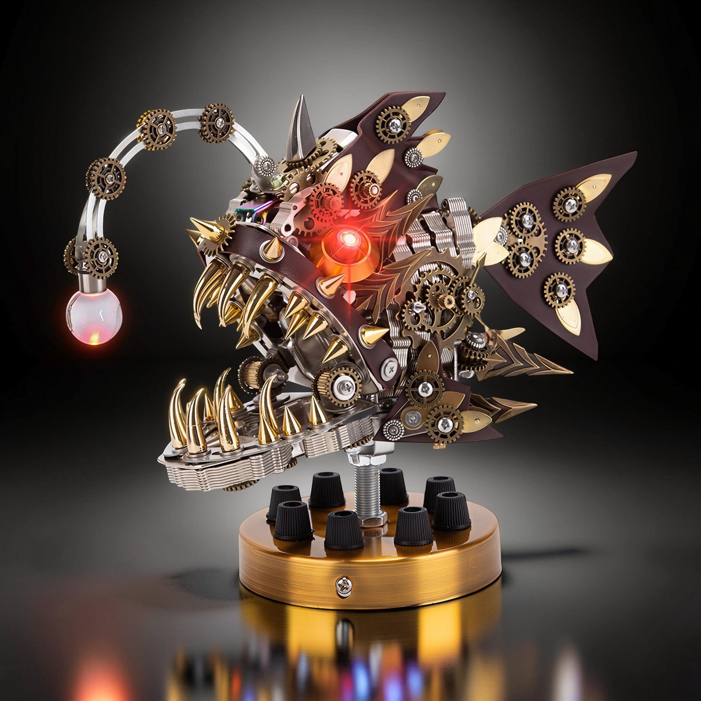 The Curious Mind Steampunk Anglerfish metal model kit with display base, featuring intricate gears, leather accents, and a glowing red eye.