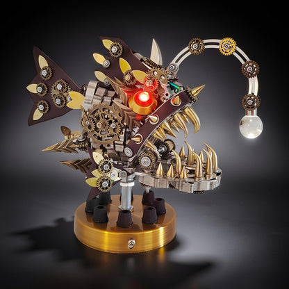 The Curious Mind Steampunk Anglerfish metal model kit with display base, featuring intricate gears, sharp teeth, and a light-up lure.