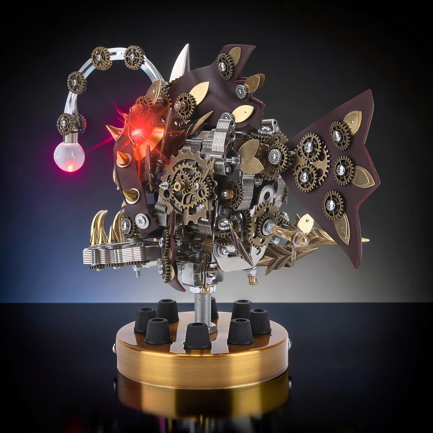 The Curious Mind Steampunk Anglerfish metal model kit with display base, featuring intricate gears, leather accents, and a glowing red light.