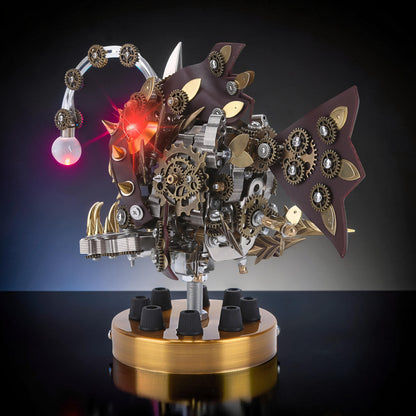 The Curious Mind Steampunk Anglerfish metal model kit with display base, featuring intricate gears, leather accents, and a glowing red light.