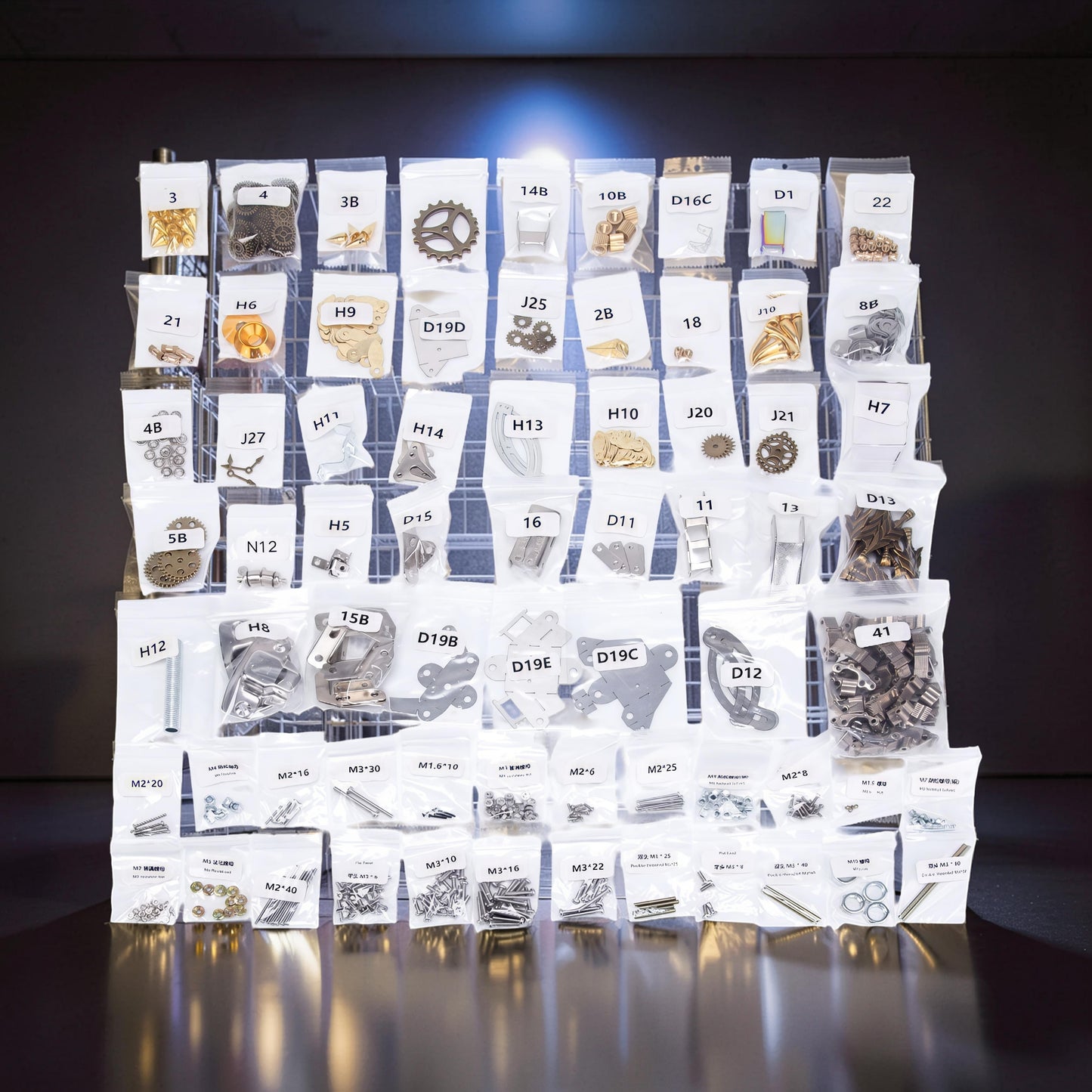 The Curious Mind Steampunk Anglerfish metal model kit parts laid out in labeled bags on a grid.