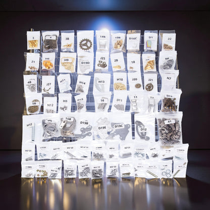 The Curious Mind Steampunk Anglerfish metal model kit parts laid out in labeled bags on a grid.