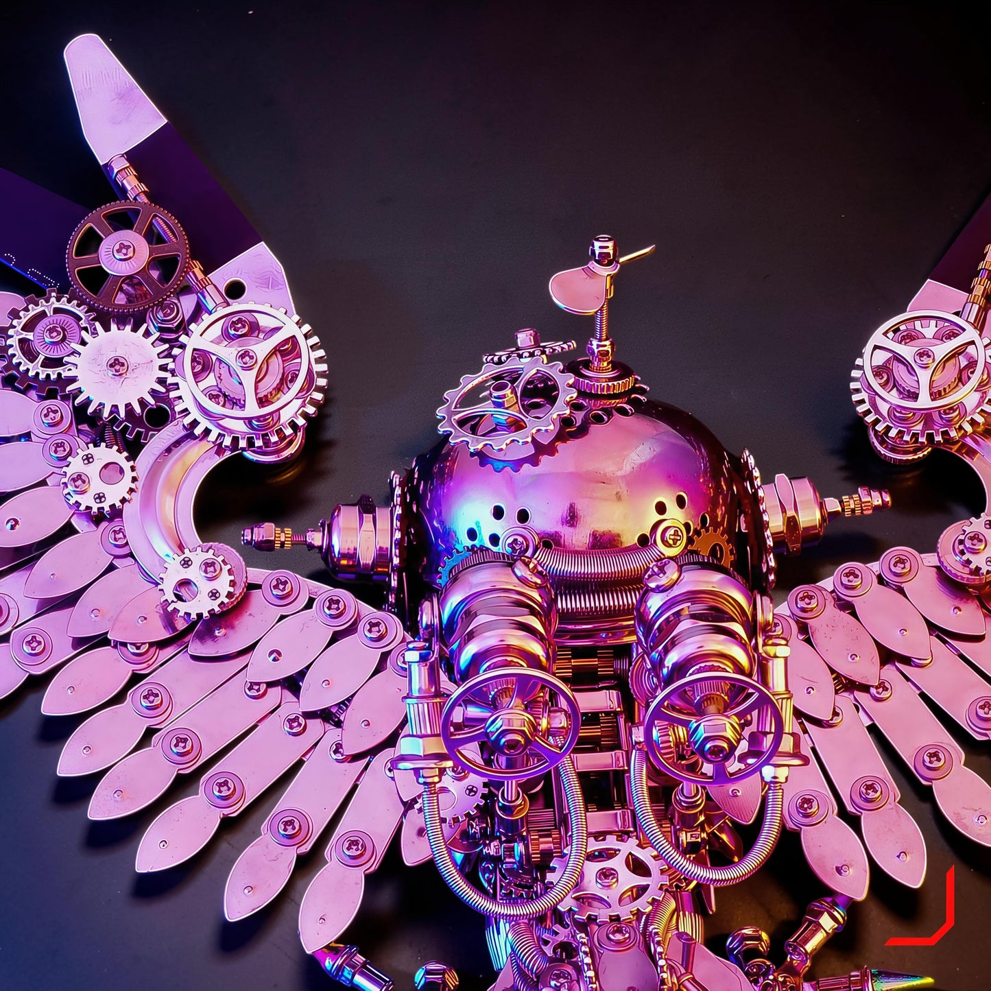 The Curious Mind Steampunk Owl 3D metal model kit with iridescent pink finish, intricate gears, and mechanical wings.