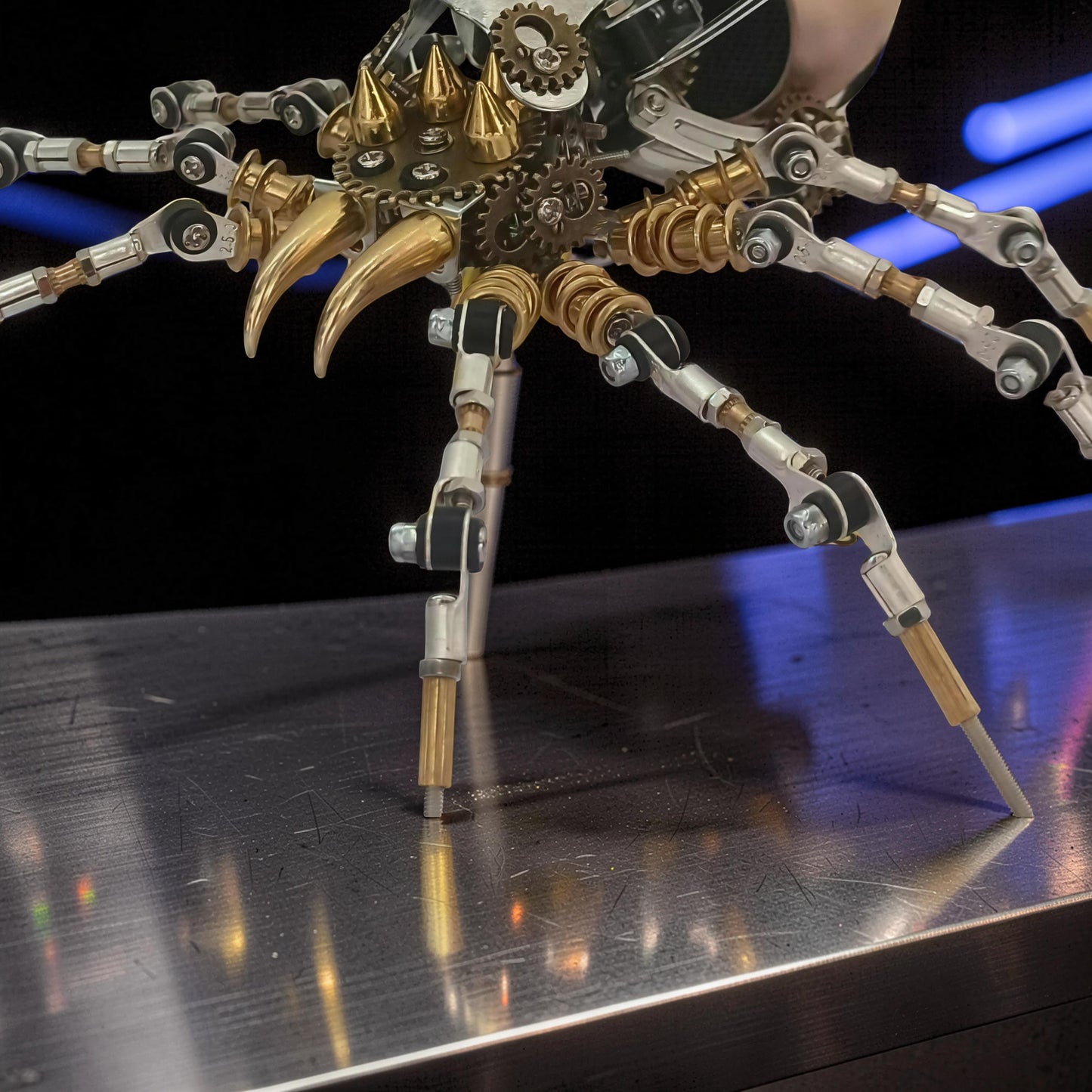 The Curious Mind Steampunk Spider Desk Lamp, a 3D metal model kit with intricate gears, brass fangs, and silver articulated legs.