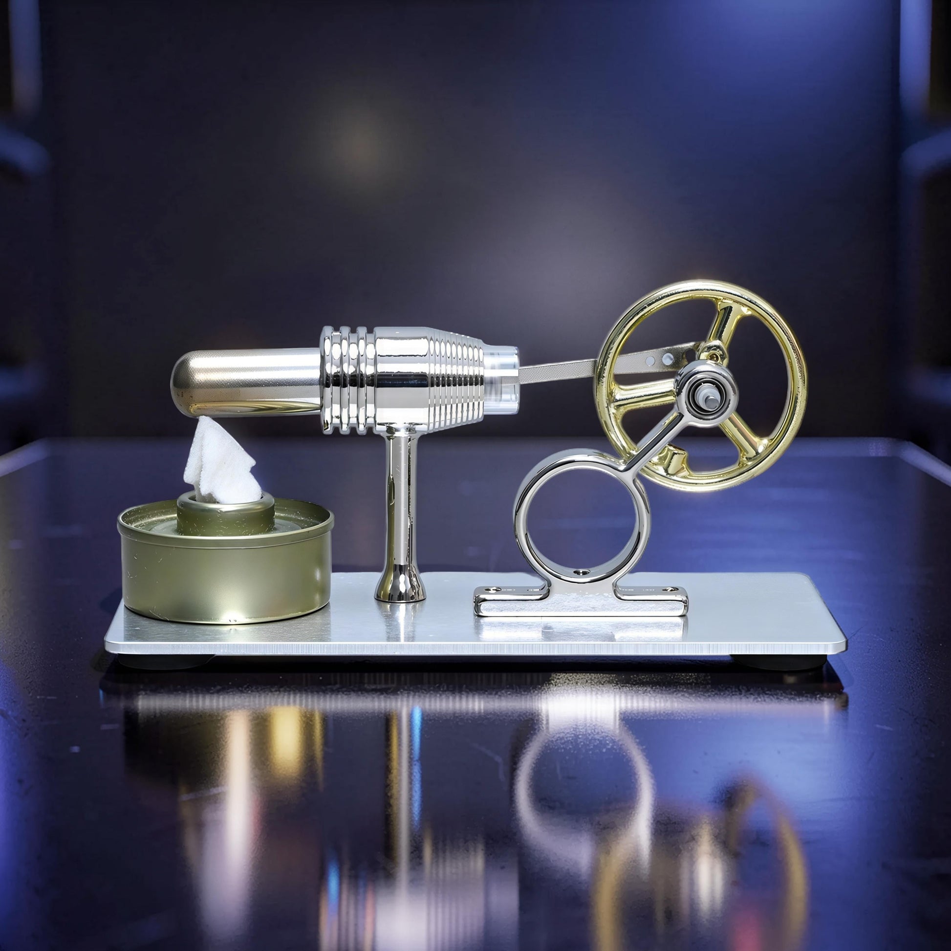 The Curious Mind Classic Stirling engine model with gold flywheel and silver metal body on a reflective surface.