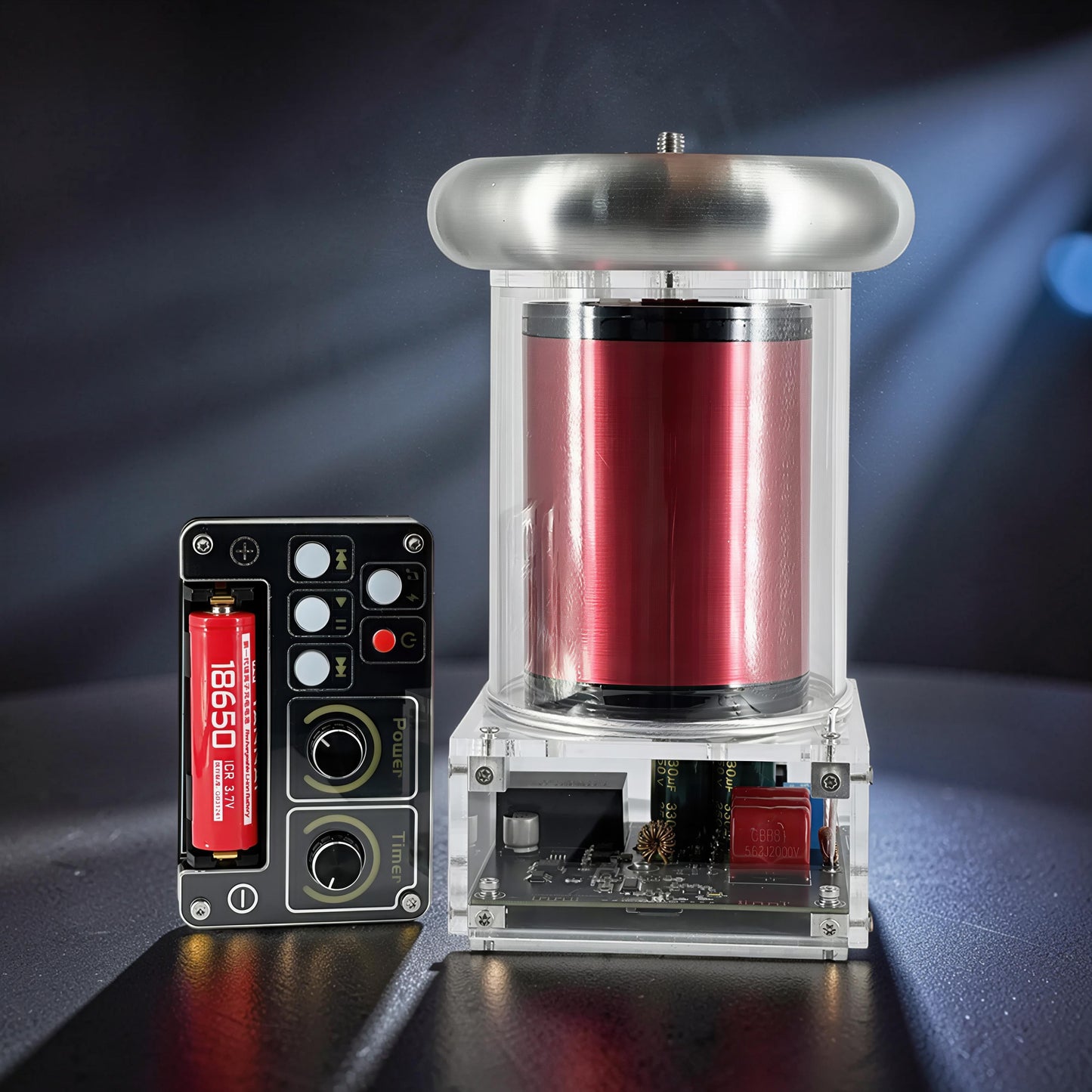 The Curious Mind Tesla Coil TC20 Plasma Science Lamp with red coil and clear casing, next to a black control unit with battery.