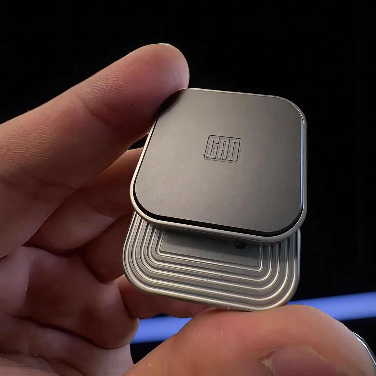 The Curious Mind Tetris Stainless Steel Slider fidget toy with a GAD logo, designed for stress relief and focus.