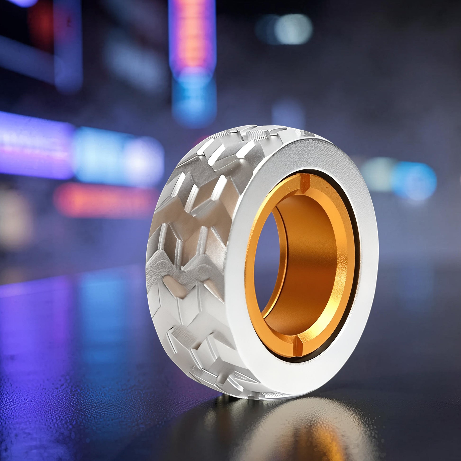 The Curious Mind Tire Haptic Ratchet Ring, a compact metal fidget ring with a gold interior and silver tire tread exterior.