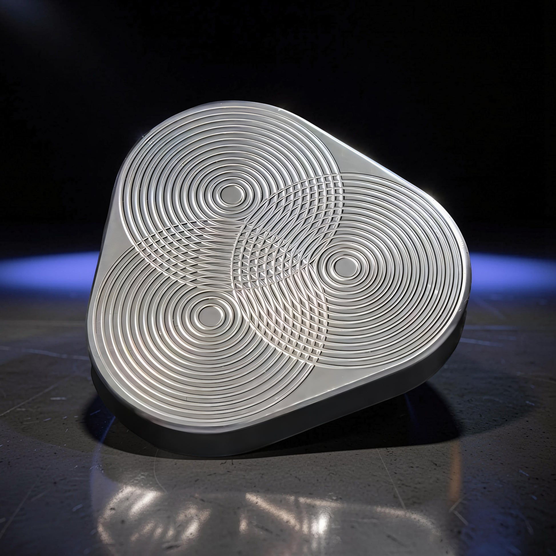 The Curious Mind silver metal triangle rotary push fidget with concentric circle design. Compact and tactile.