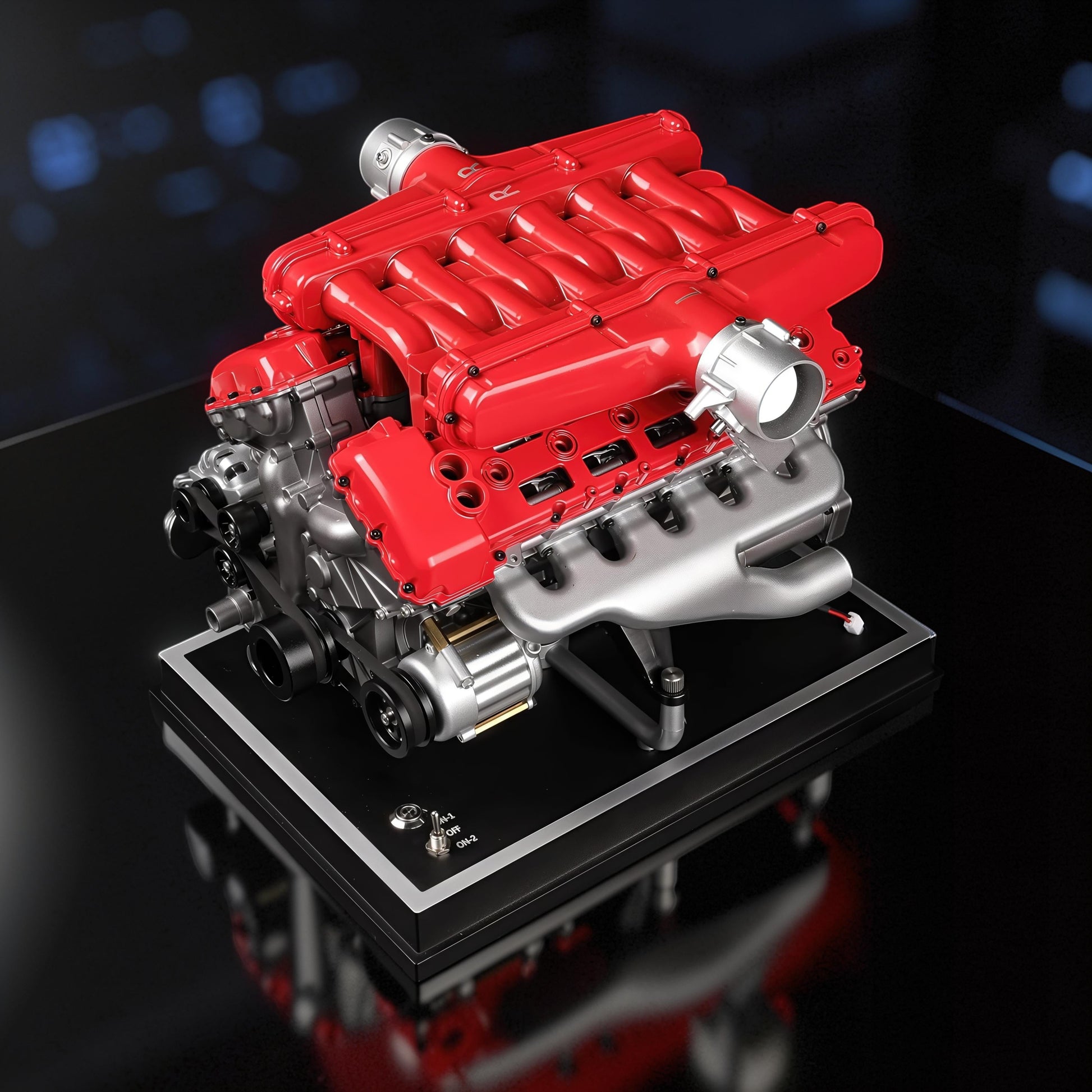 The Curious Mind V12 car engine DIY kit, a detailed metal model with red and silver components on a black display stand.
