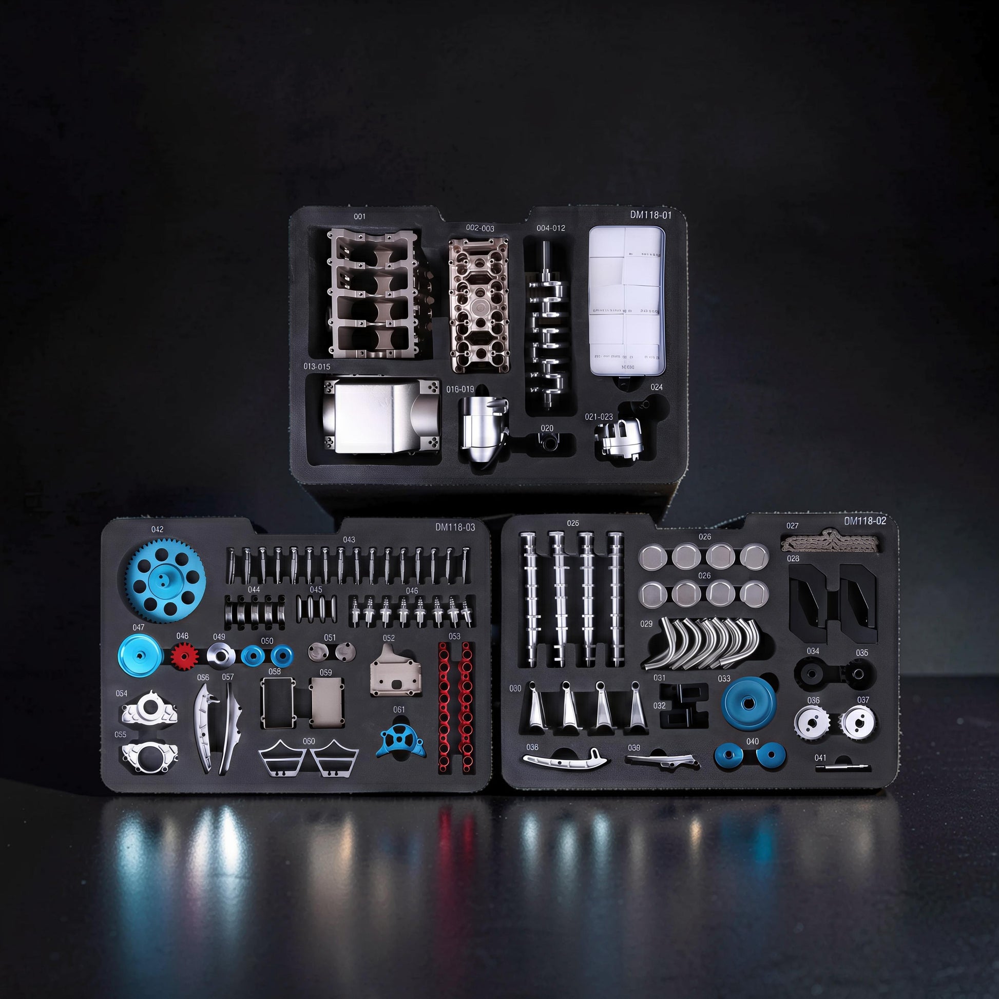 The Curious Mind V8 Car Engine DIY Kit metal mechanical model parts organised in foam trays. Includes engine block, crankshaft, pistons, gears, and screws.