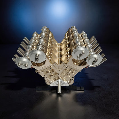 The Curious Mind V8 car engine DIY kit, a detailed metal mechanical model with gold and silver components, displayed on a stand.