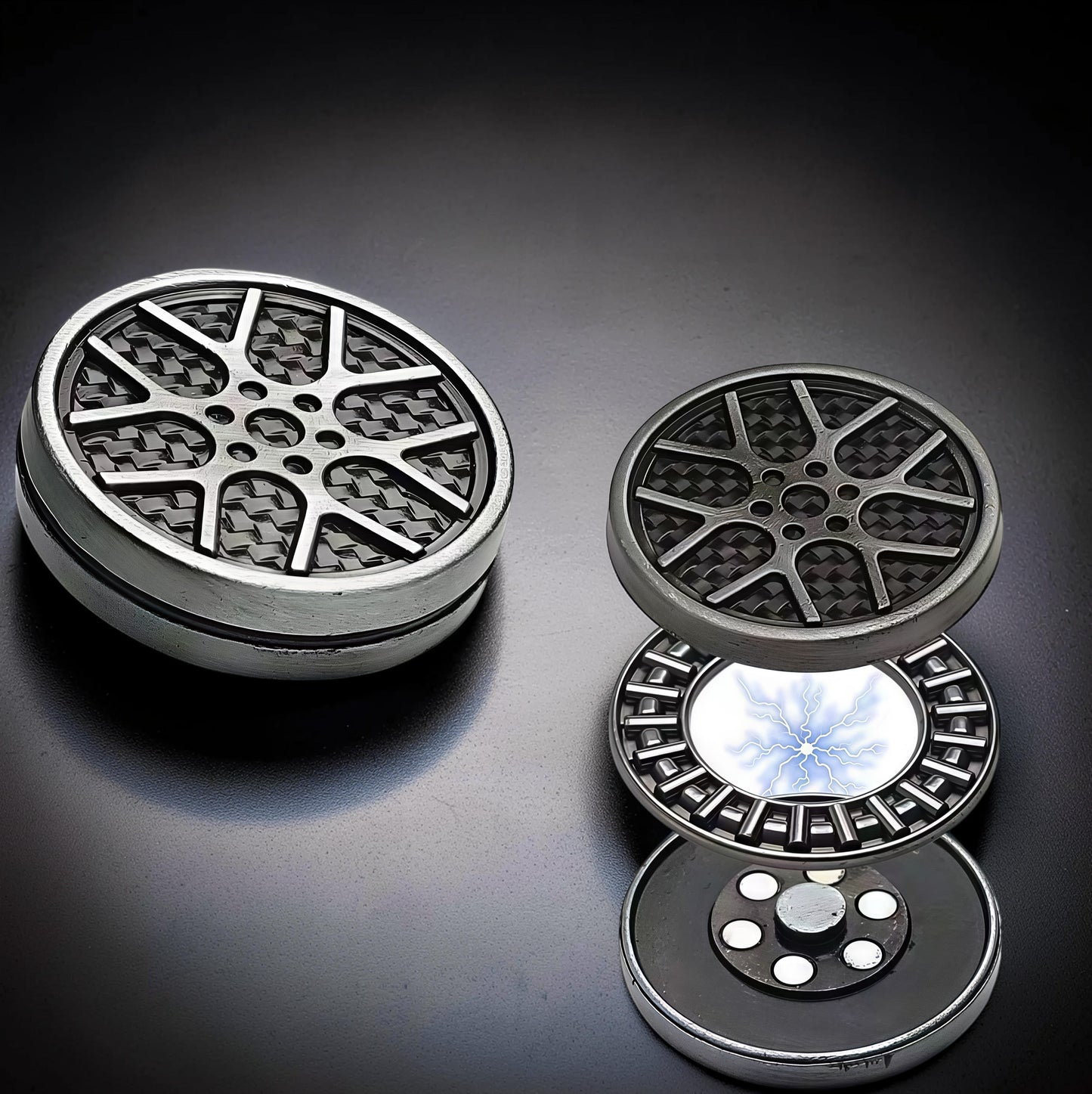 The Curious Mind Wheel Hub Coin Clicker fidget toy with a silver metal rim and carbon fiber pattern. Disassembled view shows internal components.
