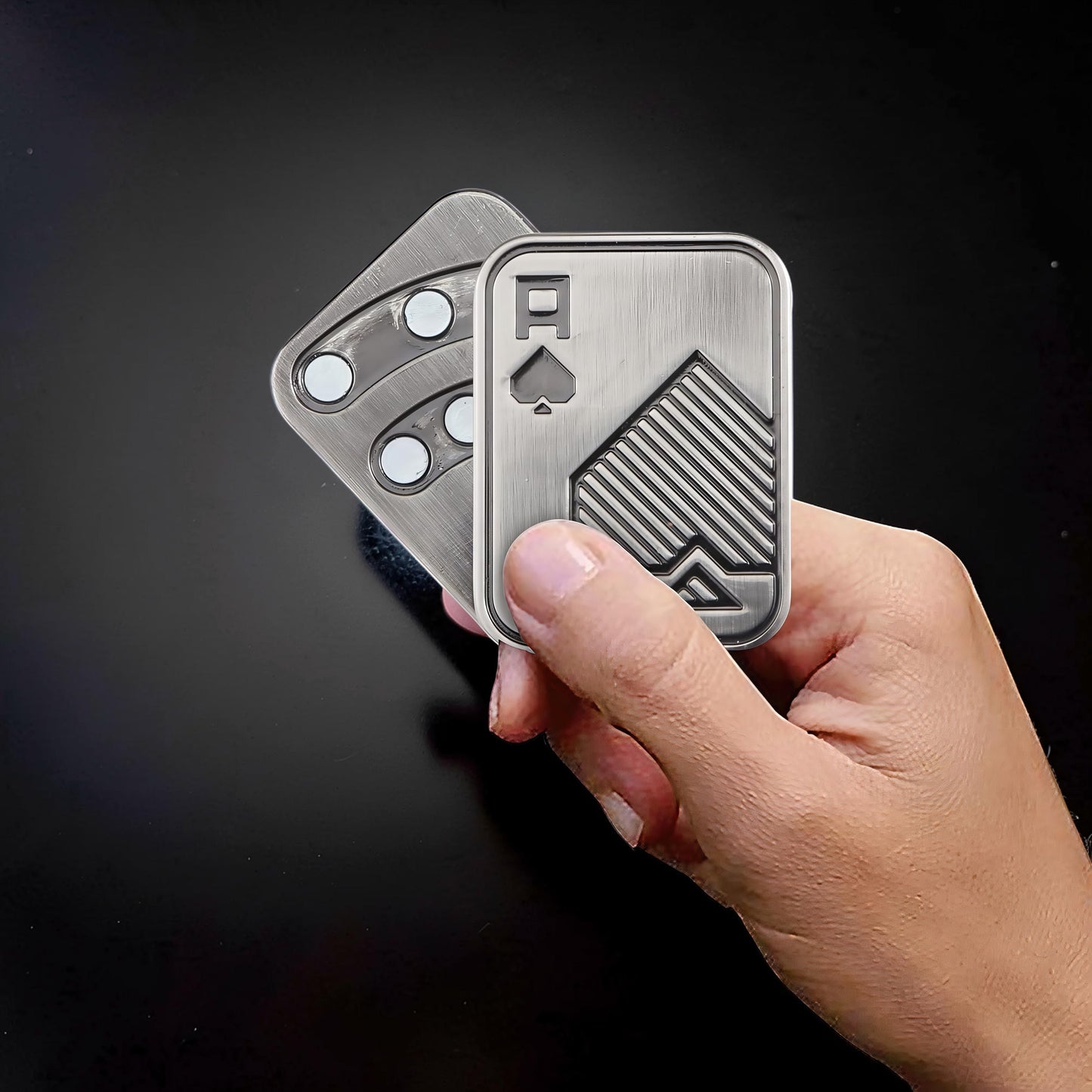 The Curious Mind Ace of Spades metal slider fidget toy, silver, compact design with tactile push-and-return motion.