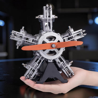 The Curious Mind 5-cylinder aircraft radial engine mechanical model kit with orange propeller, made of metal.