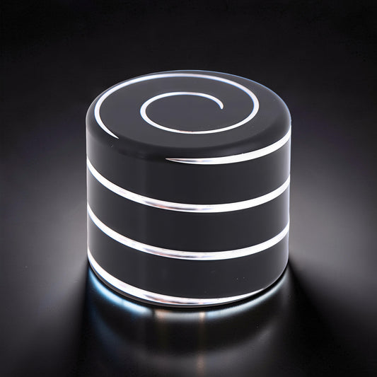 The Curious Mind Vortecon Kinetic Desk Spinner, a weighted black metal cylinder with silver spiral top and bands, for focus and stress relief.