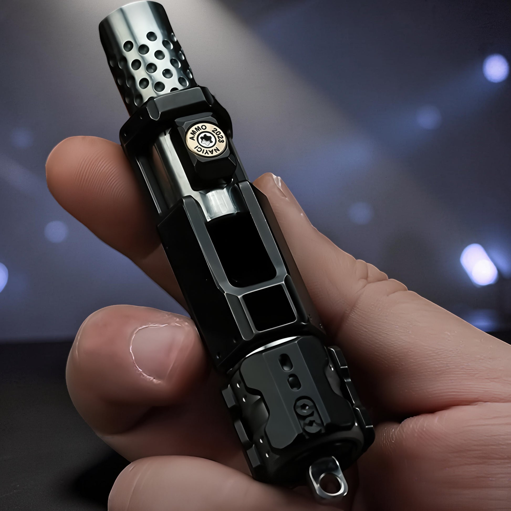 The Curious Mind Musketeers Snap Coin Clicker fidget toy, black metal, compact, gun-shaped design with perforated muzzle.