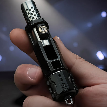 The Curious Mind Musketeers Snap Coin Clicker fidget toy, black metal, compact, gun-shaped design with perforated muzzle.
