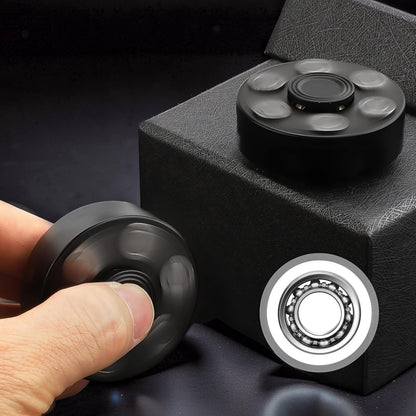 The Curious Mind black metal finger gyro spinner with six outer weights and a central bearing, shown in use and on display.