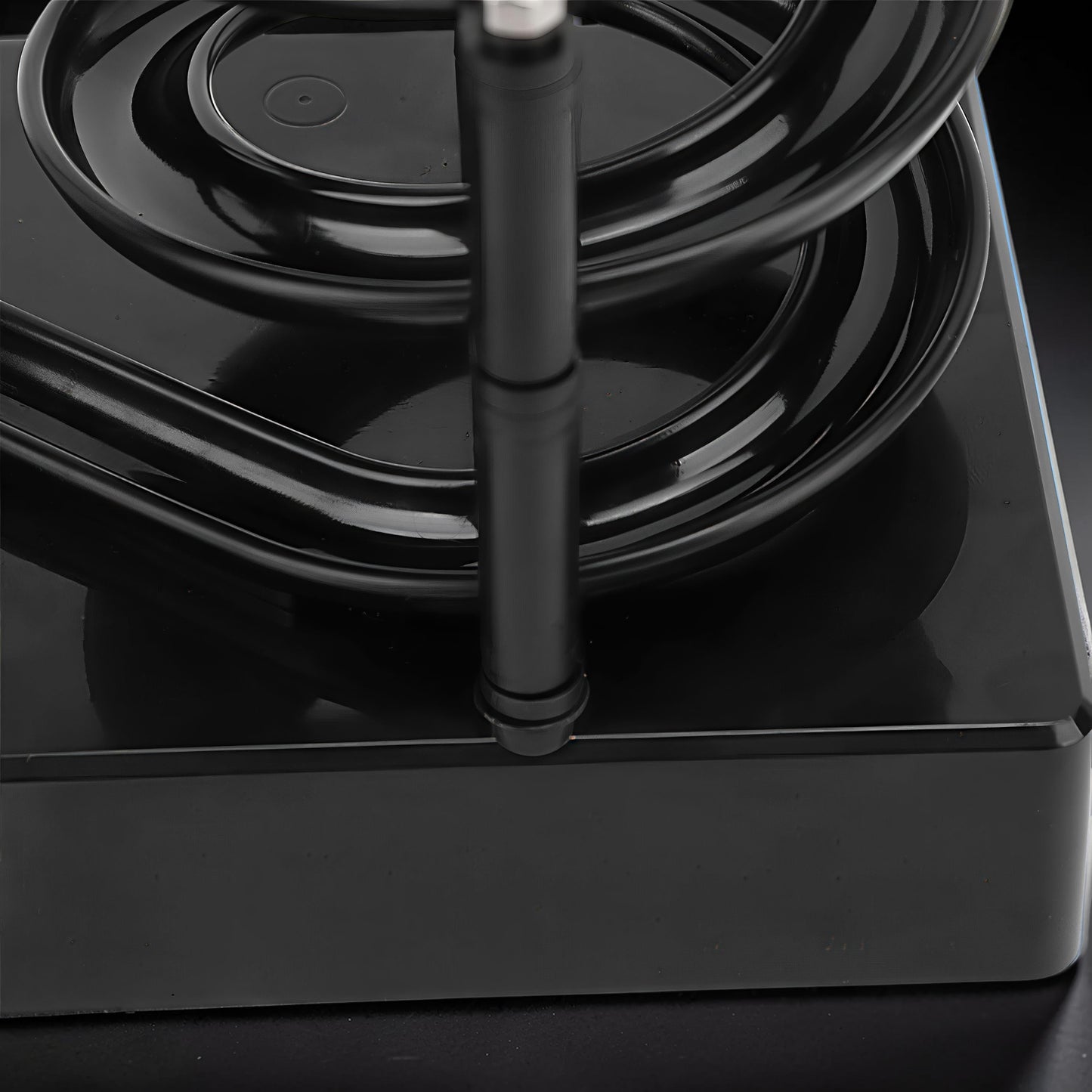 The Curious Mind black electromagnetic perpetual motion machine, a kinetic desk toy made of wood, metal, and magnet.