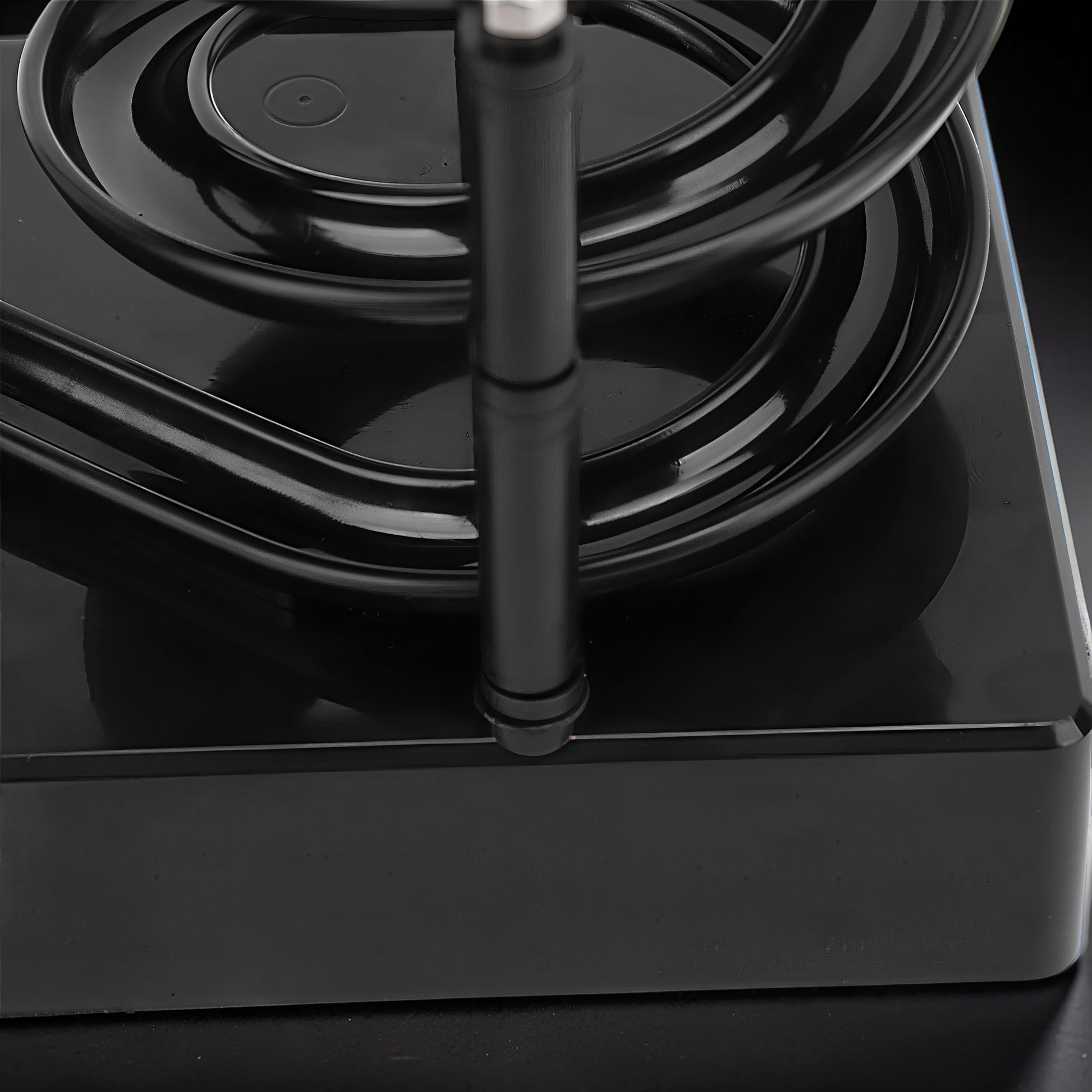 The Curious Mind black electromagnetic perpetual motion machine, a kinetic desk toy made of wood, metal, and magnet.