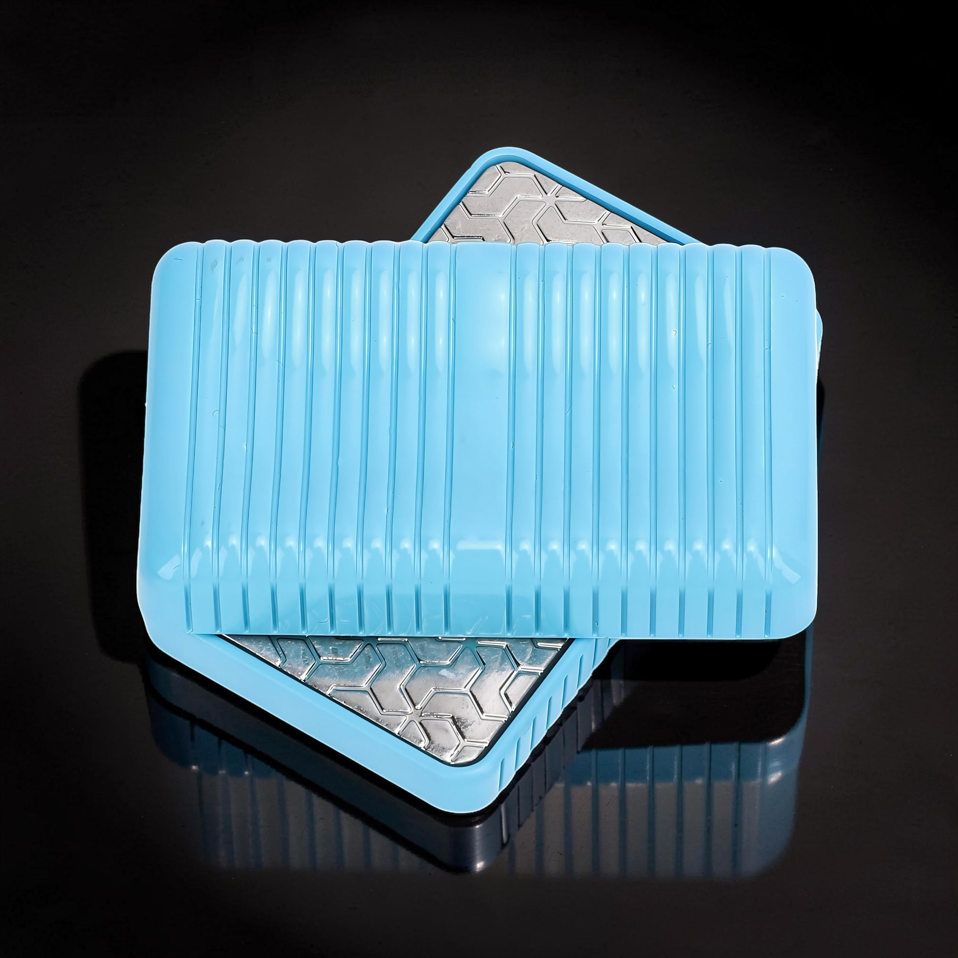 The Curious Mind blue magnetic slider fidget toy with ribbed texture and geometric metal interior.