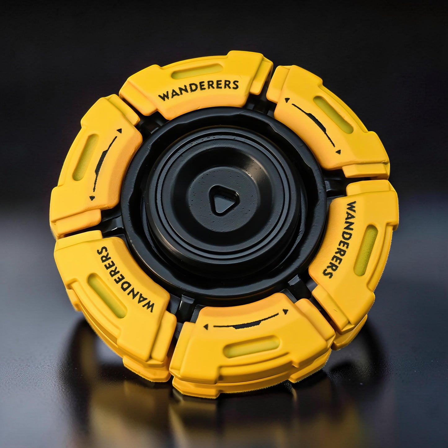 The Curious Mind Bumblebee Metal Spinner fidget toy in yellow and black, featuring 'WANDERERS' text and arrows.