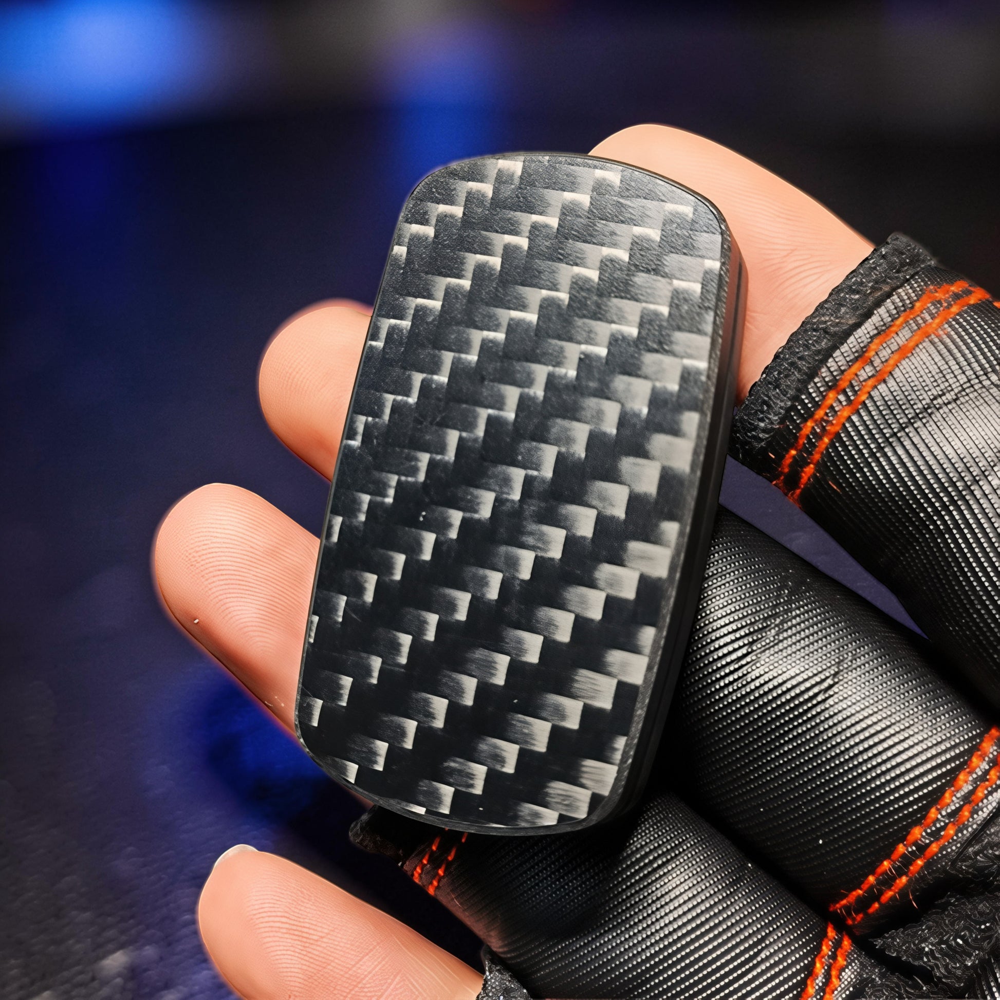 The Curious Mind Carbon Fiber Magnetic Slider fidget toy with a woven carbon fiber pattern, held in a hand.